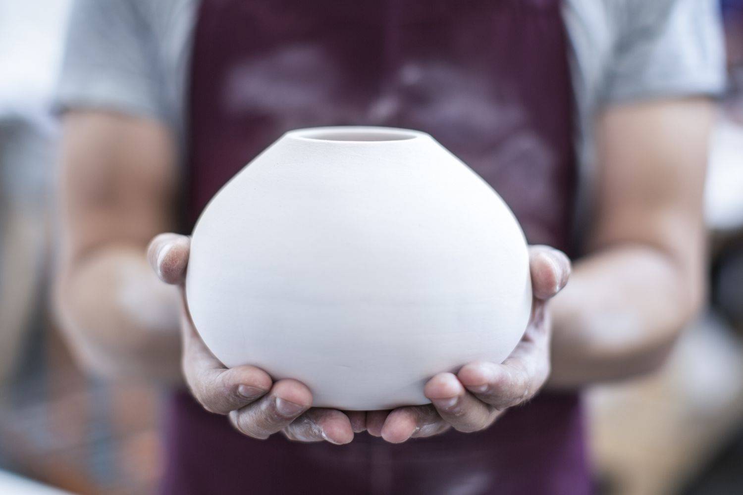 Person holding a ceramic pot