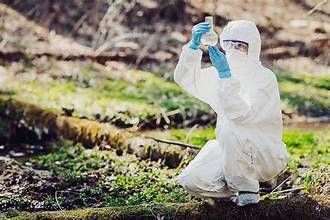 Man in white suit looking at bottle in nature