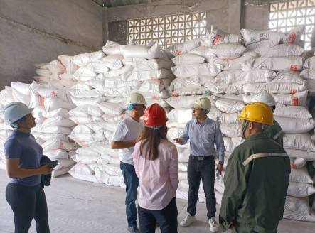 Image of workers discussing, with supplies in the background