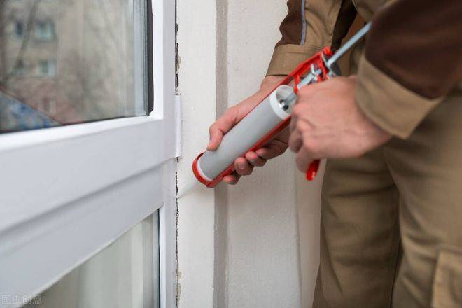 Application of chloroprene rubber adhesive by worker with caulking gun